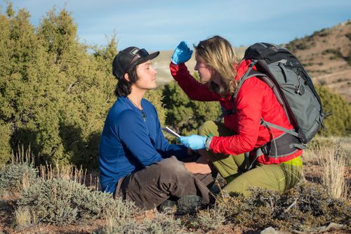 Student assessing a patient's eyes in the field
